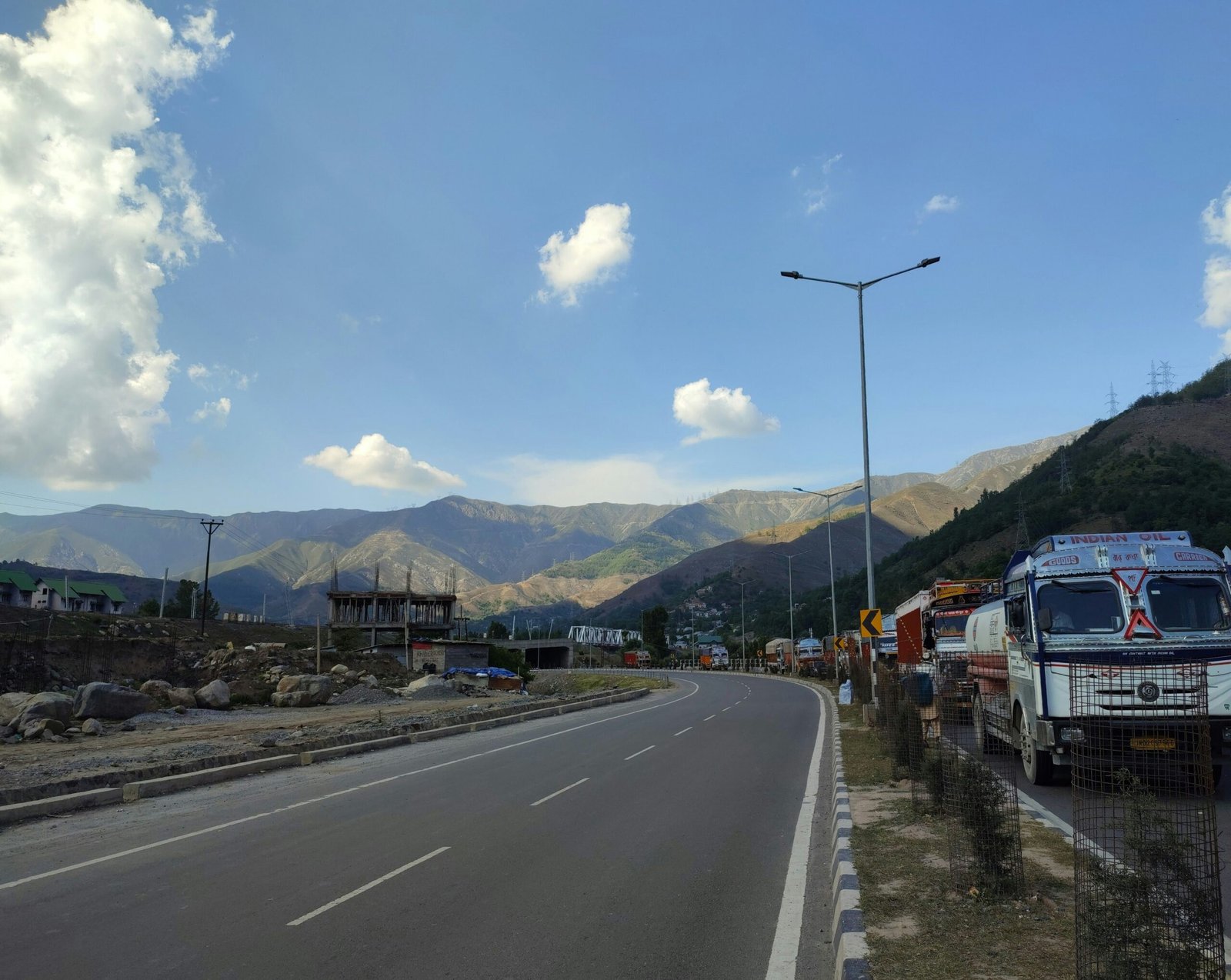 White delivery van driving on a scenic road near vast mountains