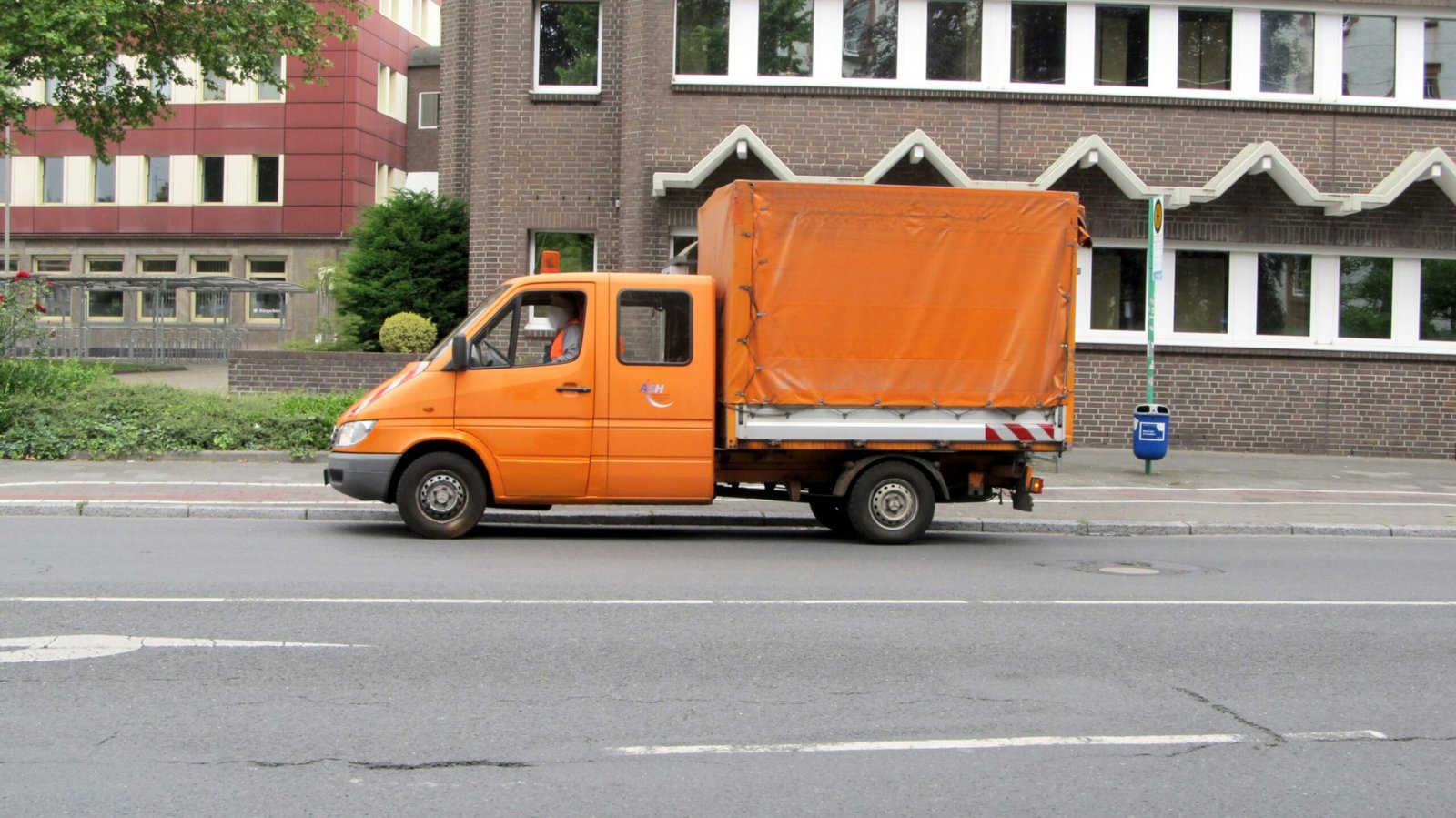 Close up of hands securing cargo with orange straps inside a truck logistic safety