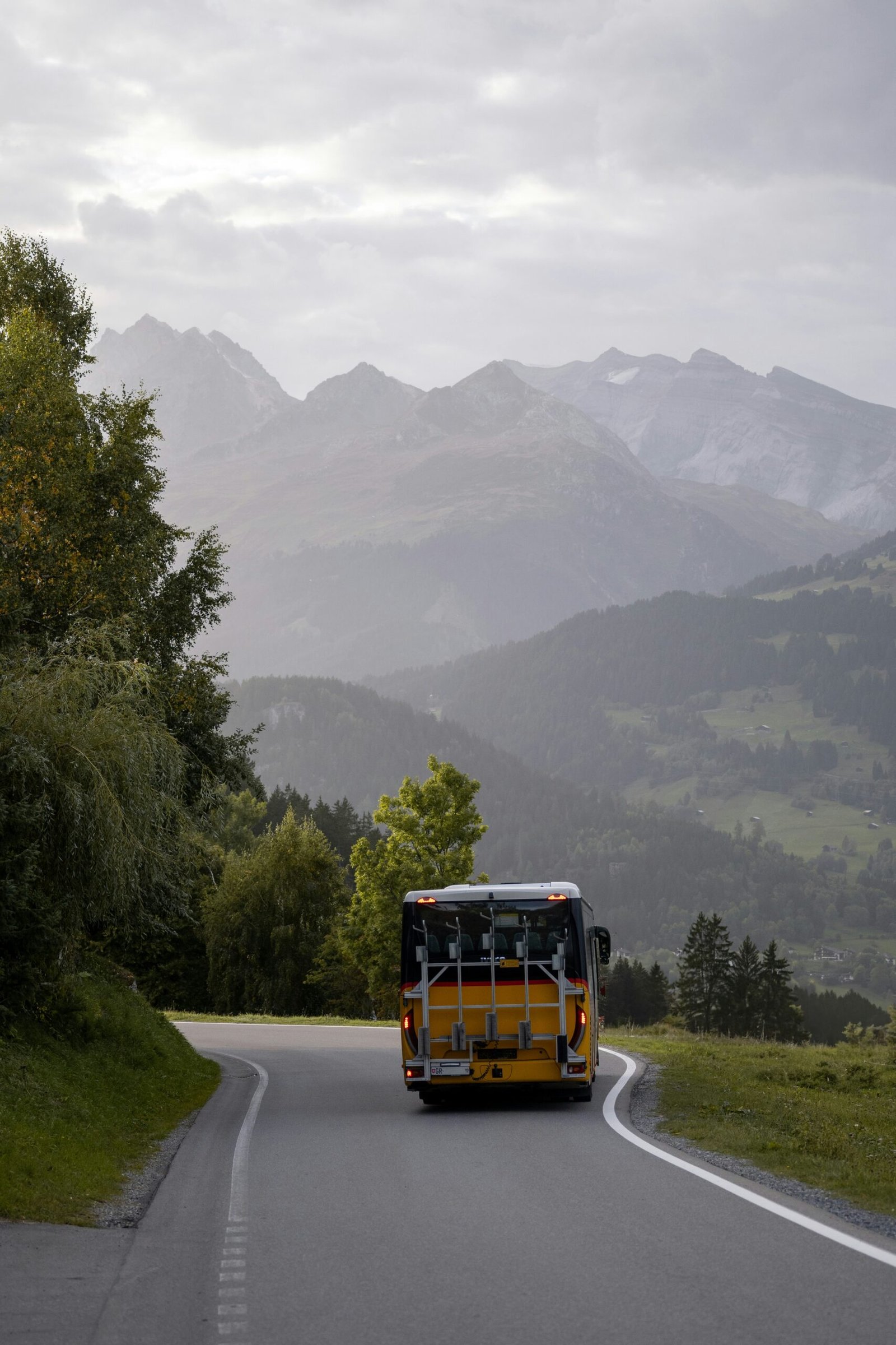 Scenic road in Switzerland with a delivery van driving through mountains