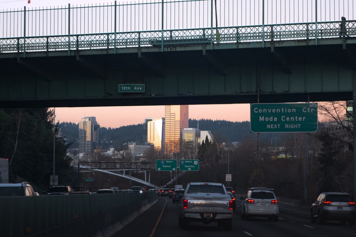 City skyline seen from a highway at sunset.