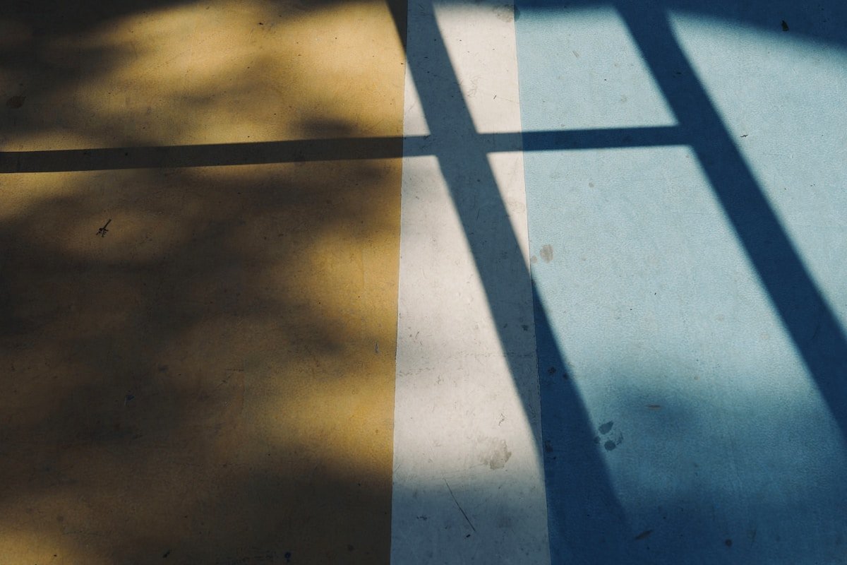 the shadow of a bench on the ground