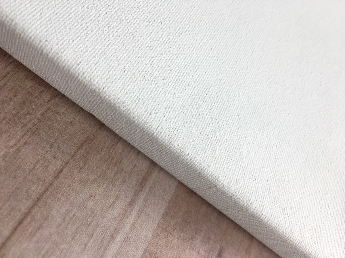 a close up of a white canvas on a wooden surface