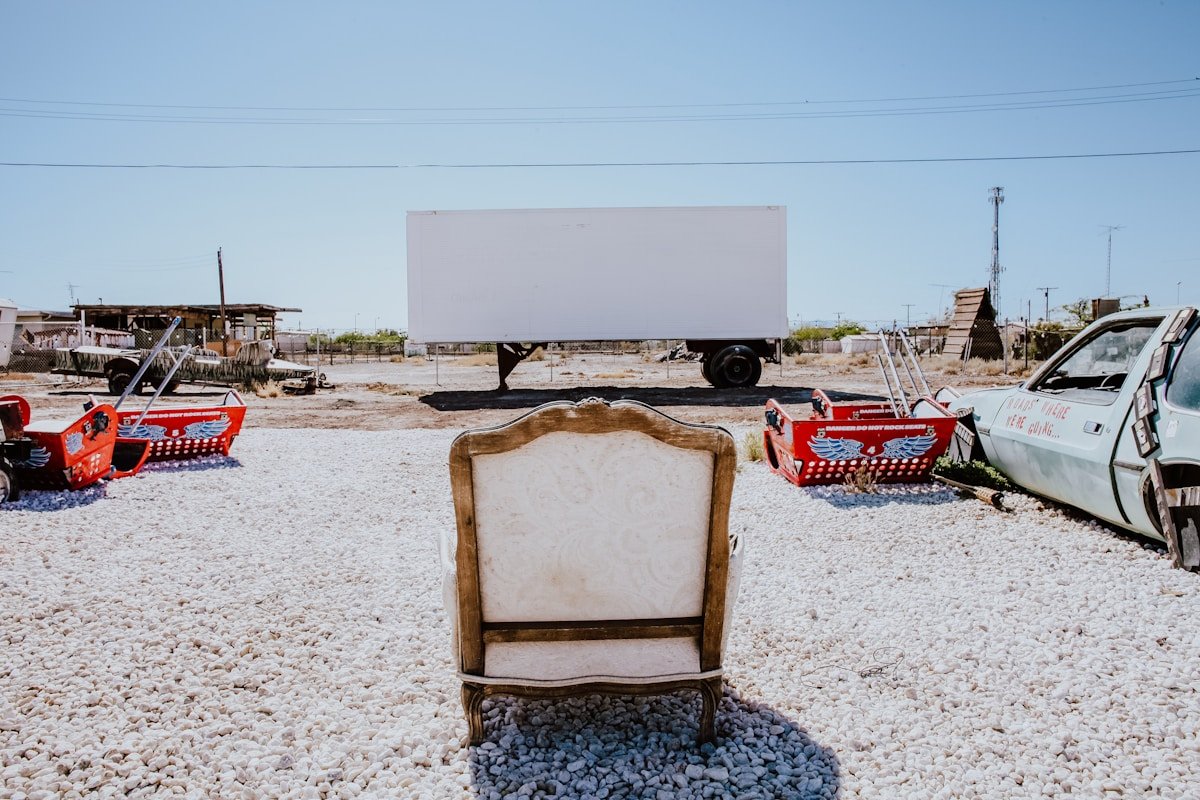 Paysage désertique avec un écran de cinéma mobile et des objets vintage.