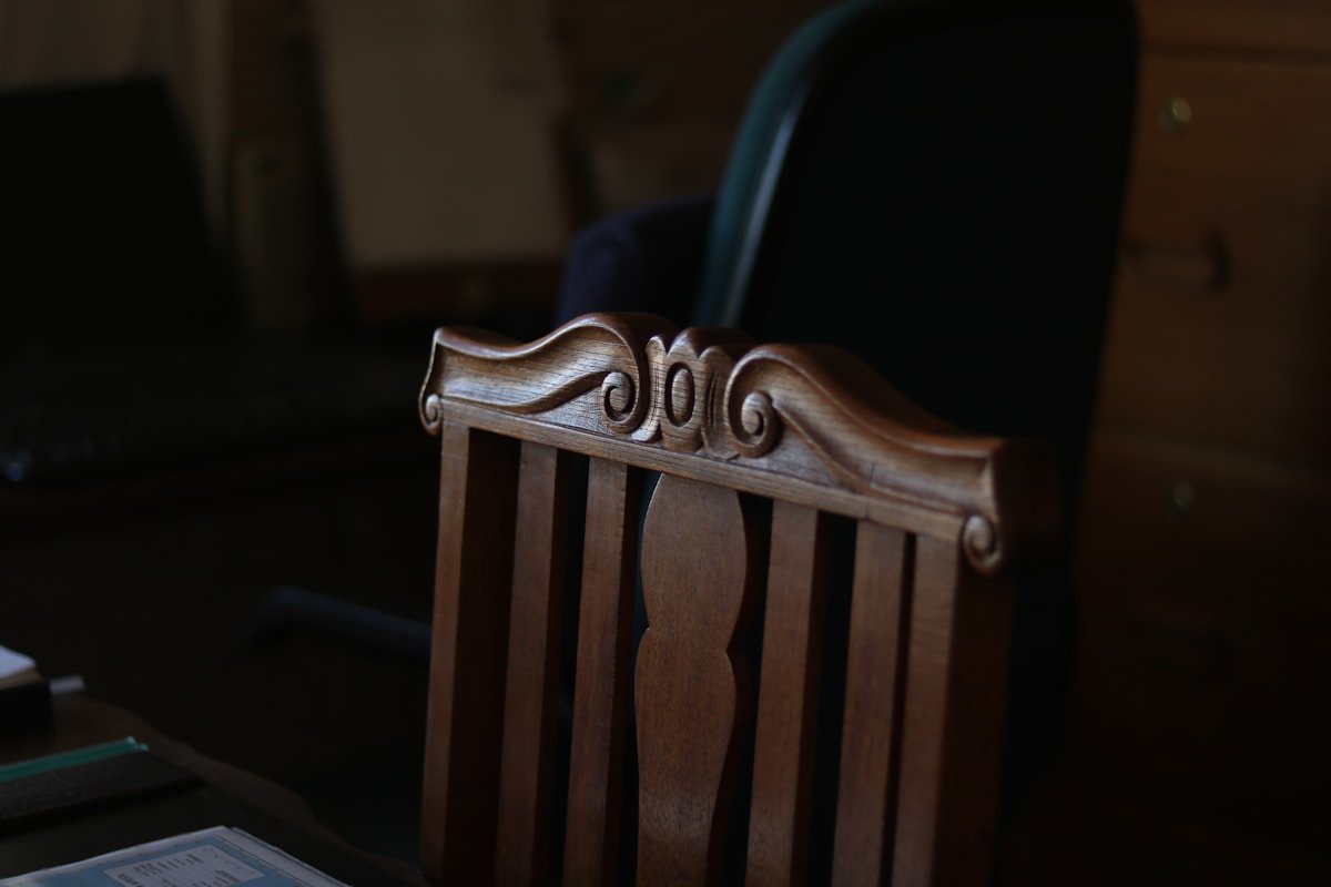 Chaise en bois brun sans accoudoirs dans une pièce.