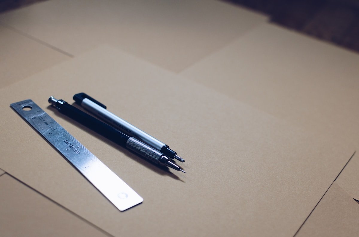 Règle, crayon mécanique et ruban sur une surface en bois.