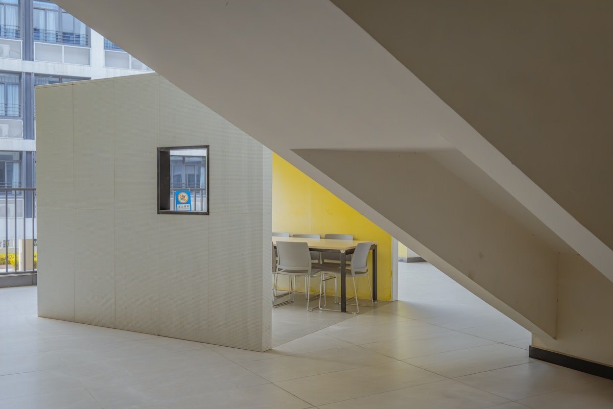 Une pièce avec une table, des chaises et une fenêtre.