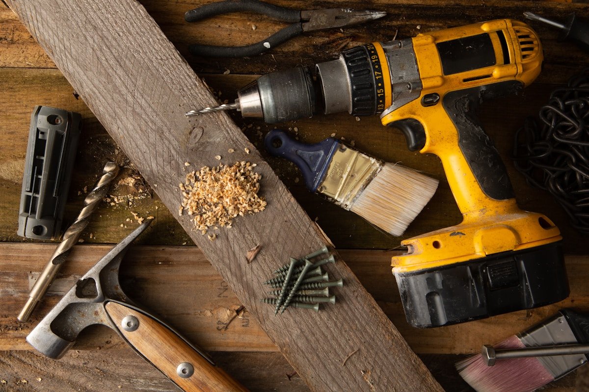 Outils de bricolage et de construction sur un plancher en bois.
