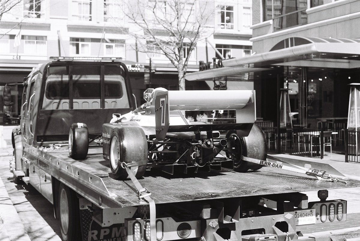 Camion de transport de voitures de course sur une rue urbaine.