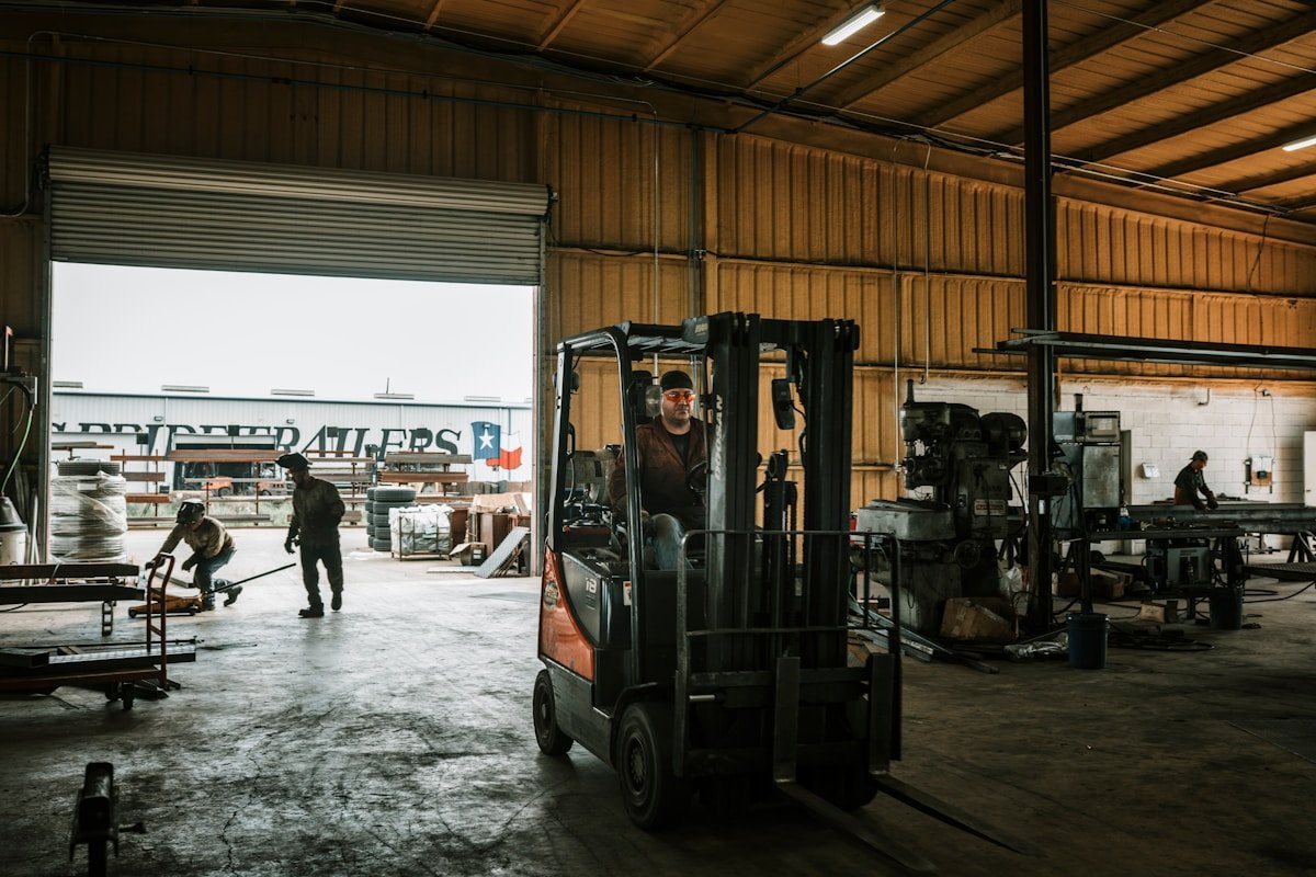 Entrepôt industriel avec chariot élévateur, outils et travailleurs.