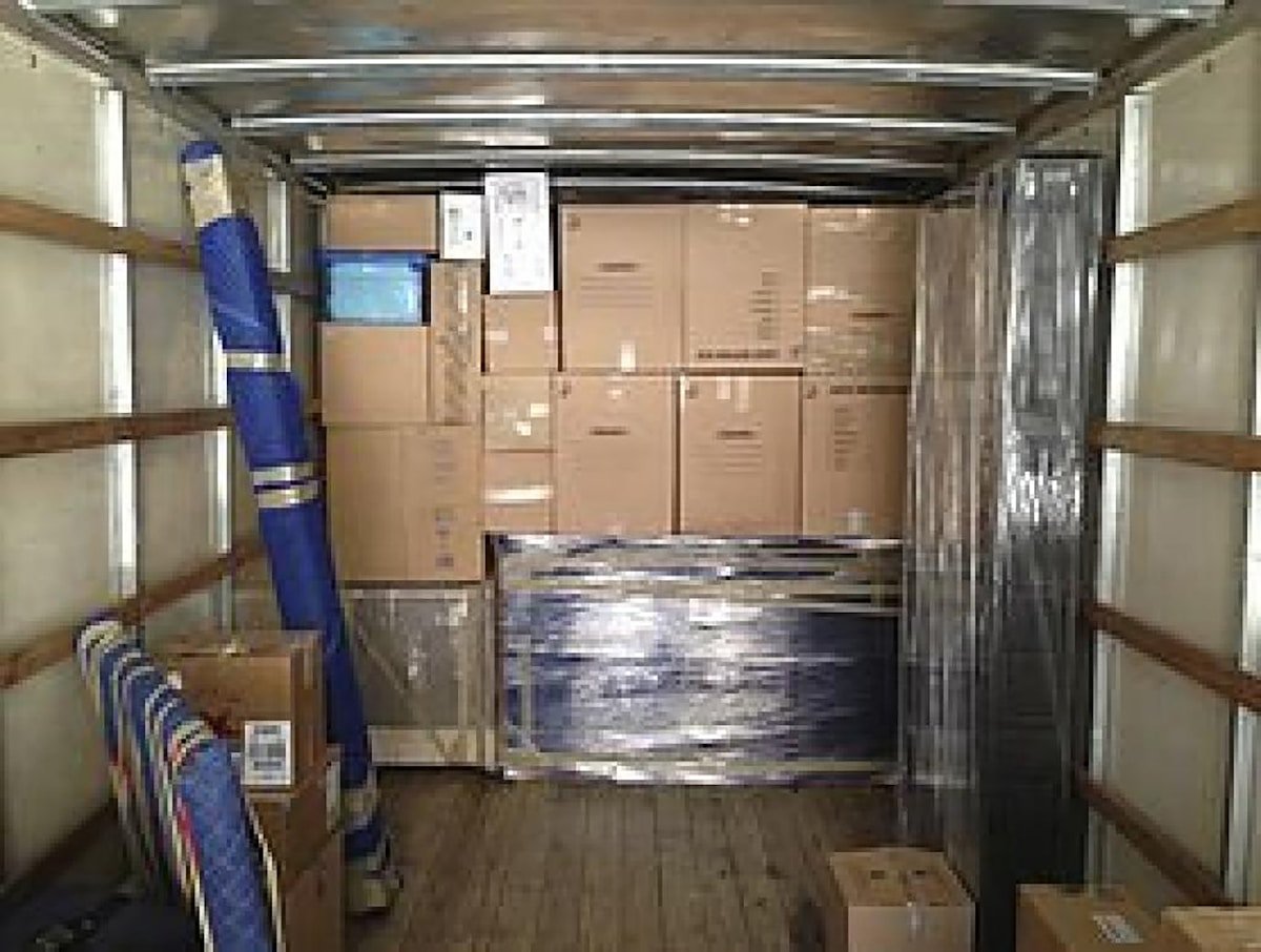 Intérieur d'un camion de déménagement rempli de boîtes et d'articles emballés.