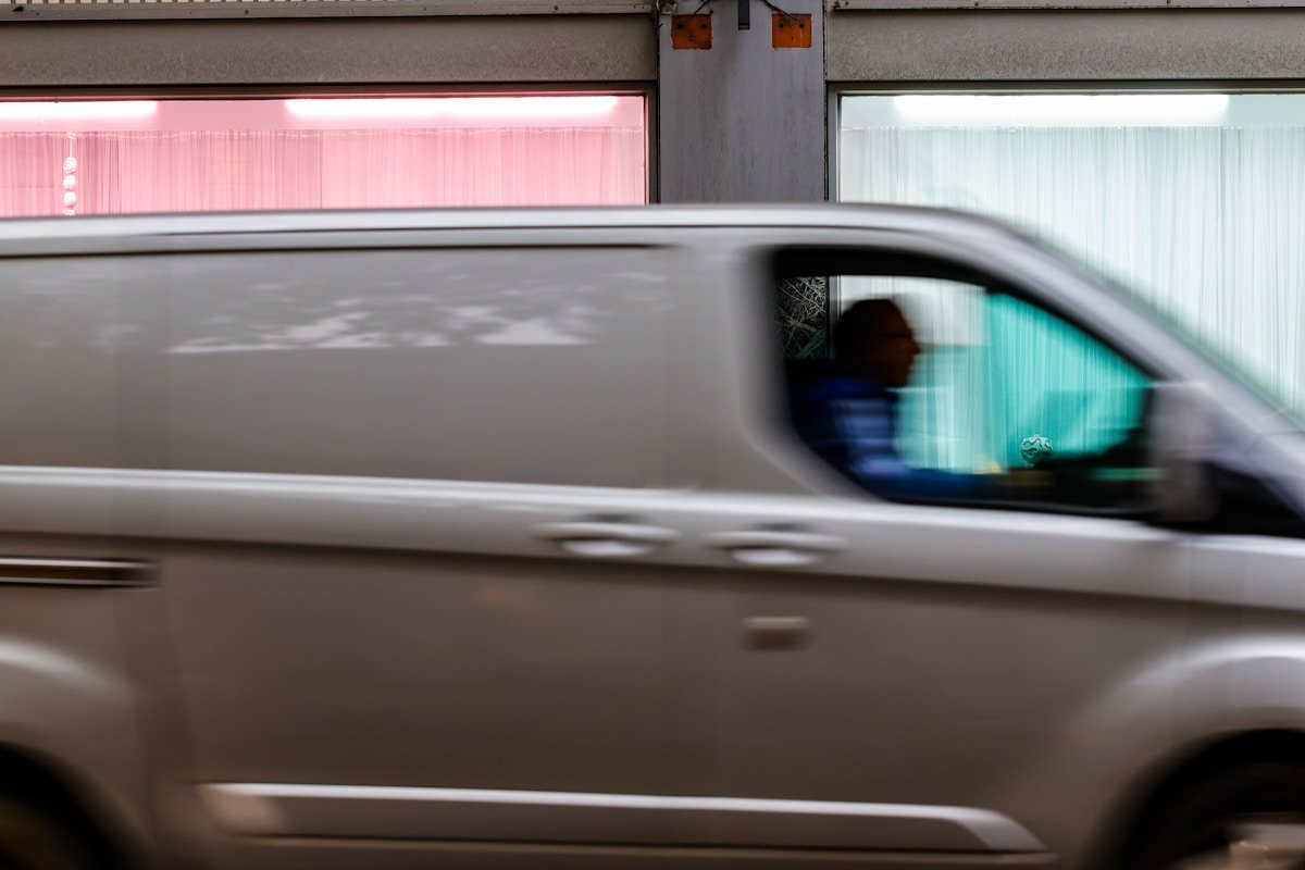 Véhicule en mouvement rapide, reflet flou dans le rétroviseur.