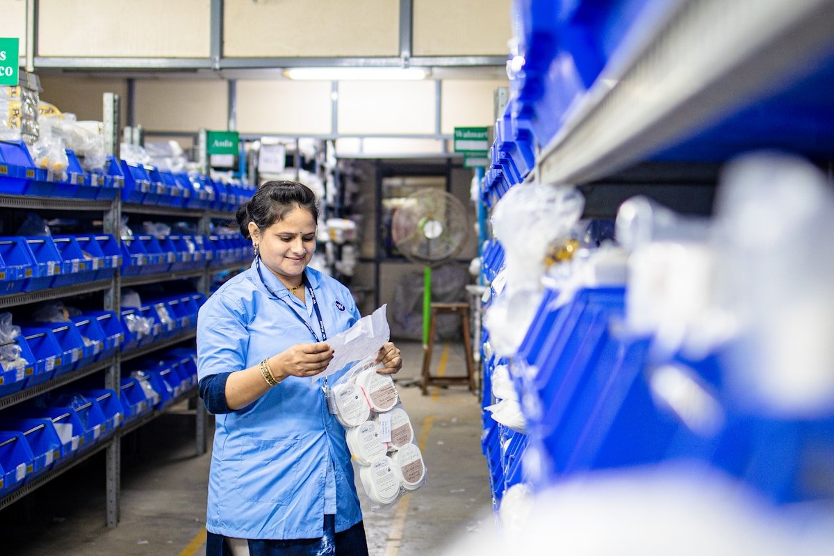 Employée d'entrepôt vérifiant des produits sur des étagères.