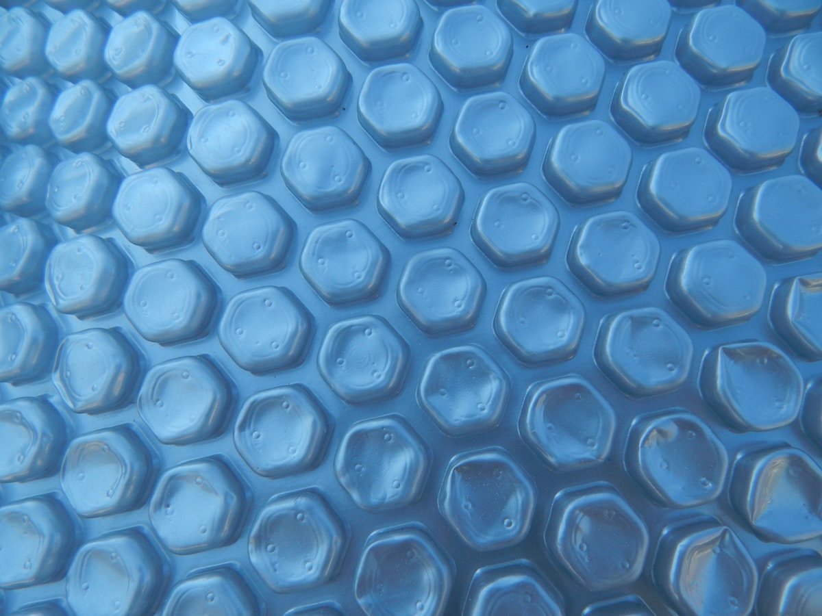 Motifs hexagonaux bleus translucides, surface texturée et brillante.