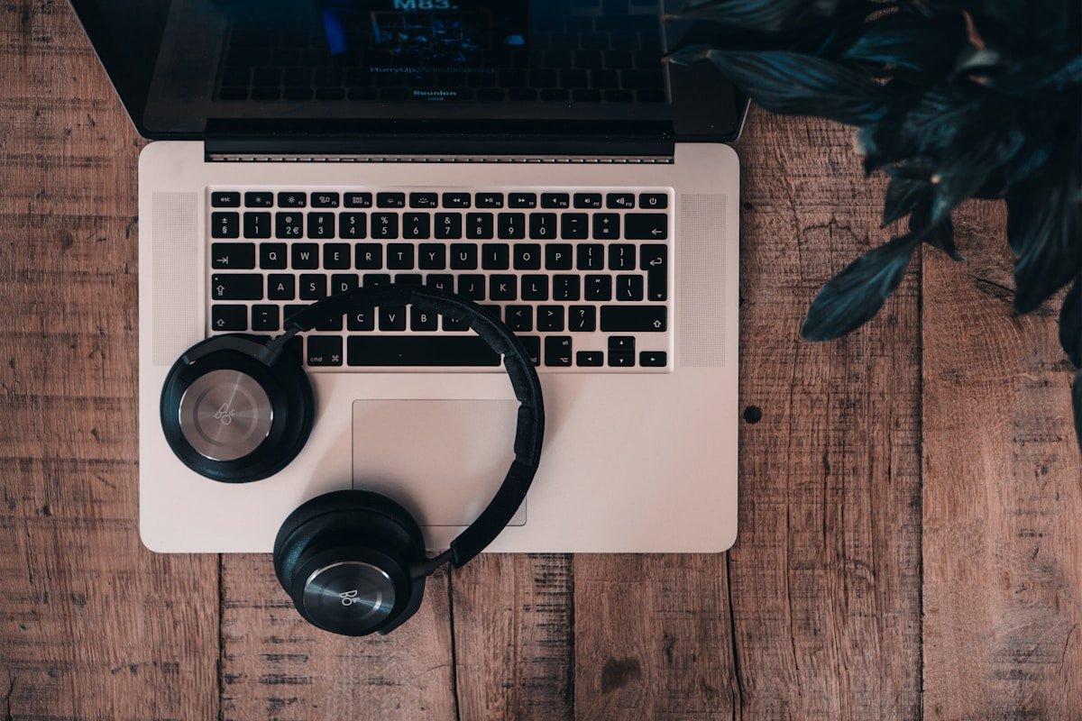 Ordinateur portable avec casque audio sur un bureau en bois.