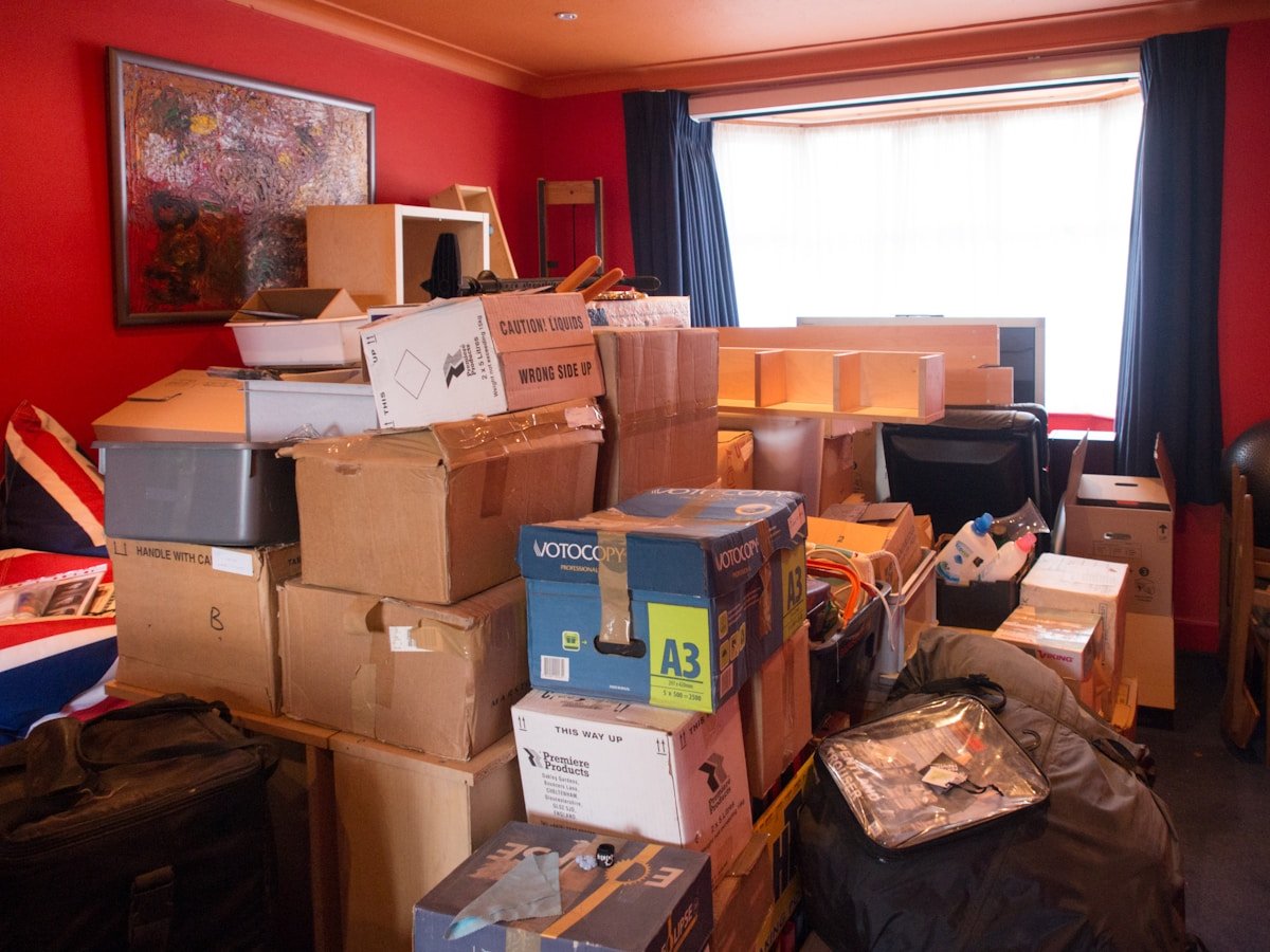 Pièce encombrée de boîtes et d'objets en désordre, prête pour un déménagement.