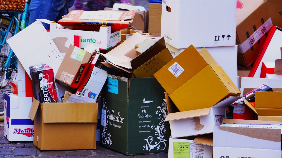 Pile de boîtes et de cartons de déménagement dans un endroit encombré.