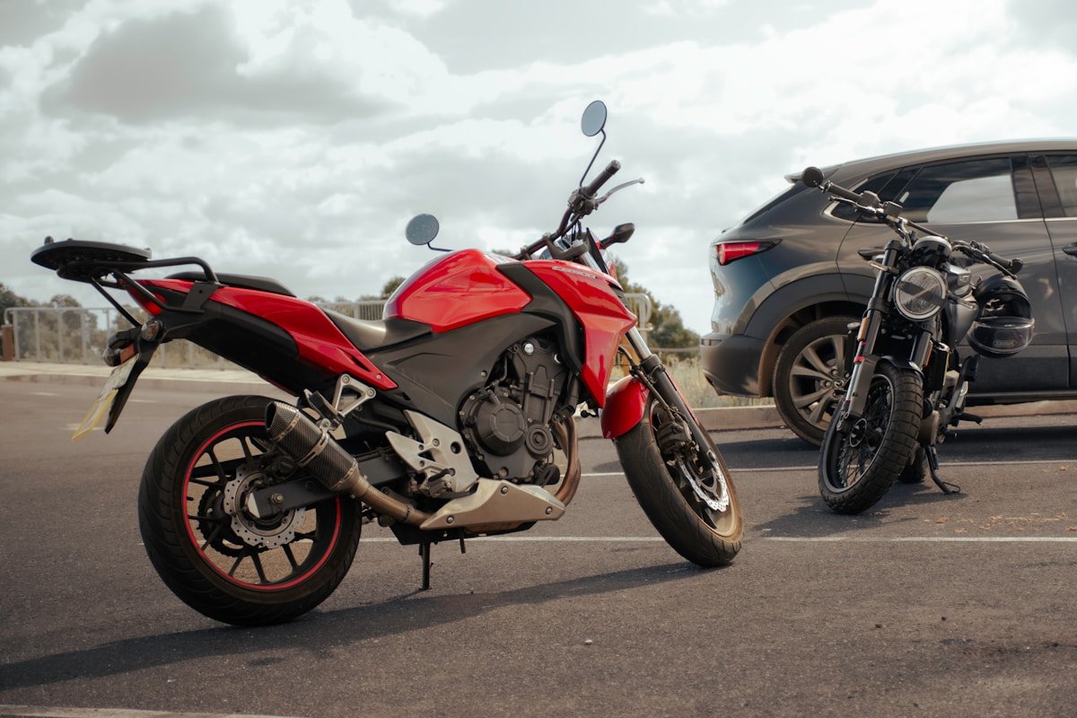 Moto rouge sportive garée à côté d'un véhicule SUV.