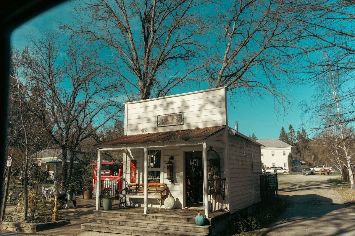 Petit magasin général avec un porche et des couronnes.