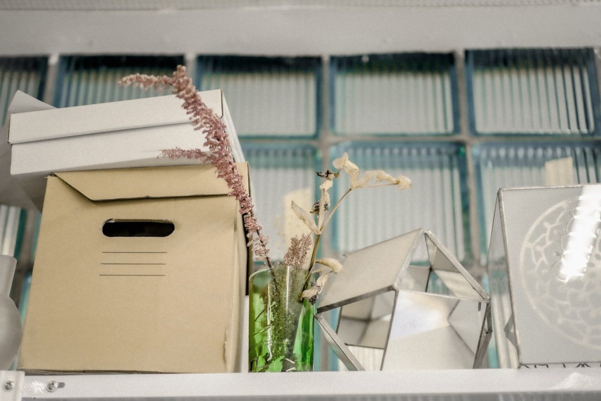 Boîtes de rangement, fleurs séchées, objets décoratifs sur une étagère.