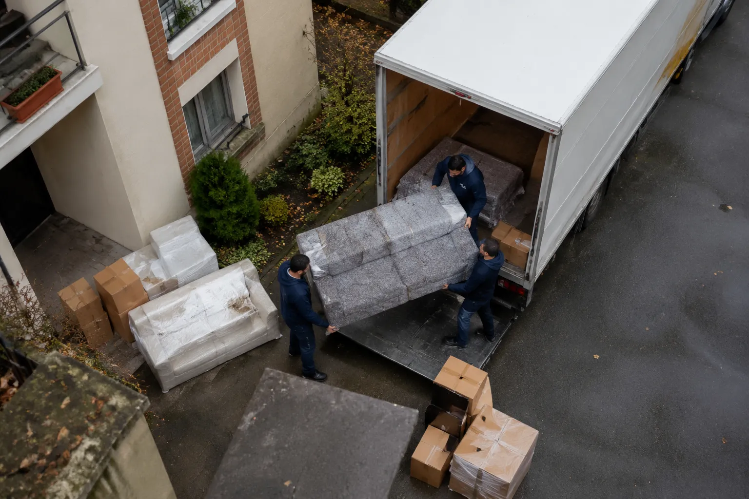 Déménageurs chargeant un canapé dans un camion de déménagement.