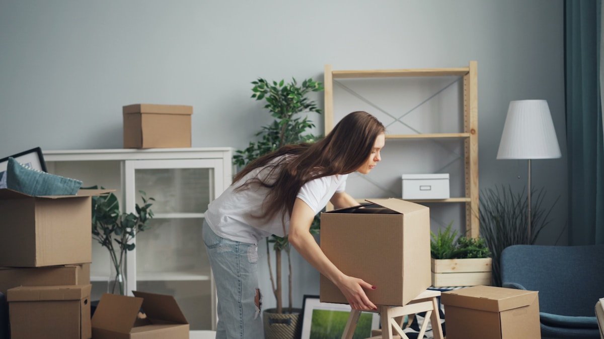 Femme déballant des boîtes dans une nouvelle maison.