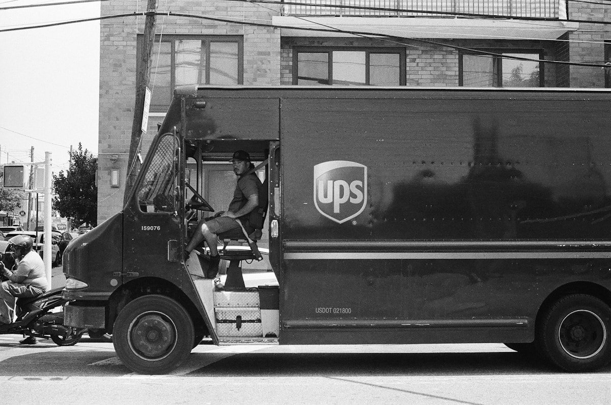 Camion de livraison UPS dans une rue urbaine en noir et blanc.