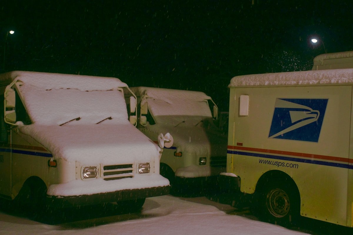 Camion postal couvert de neige dans la nuit.