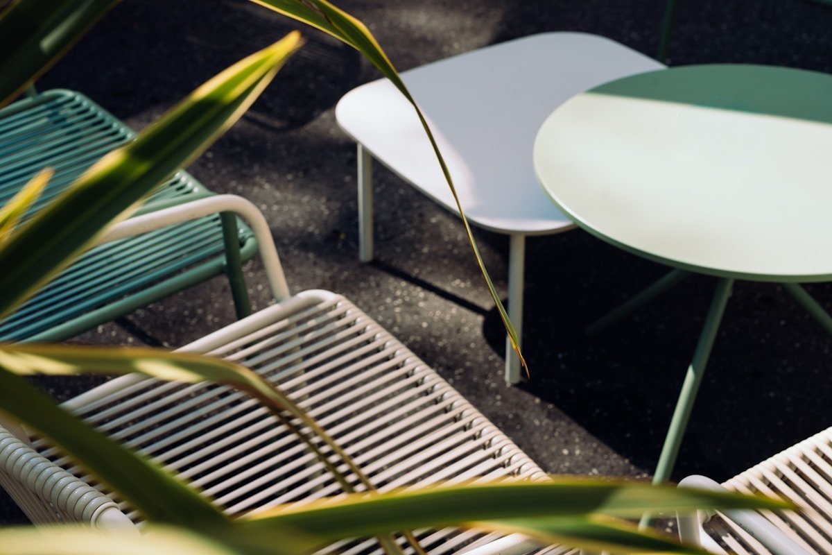 Mobilier de jardin moderne avec chaises et tables blanches.