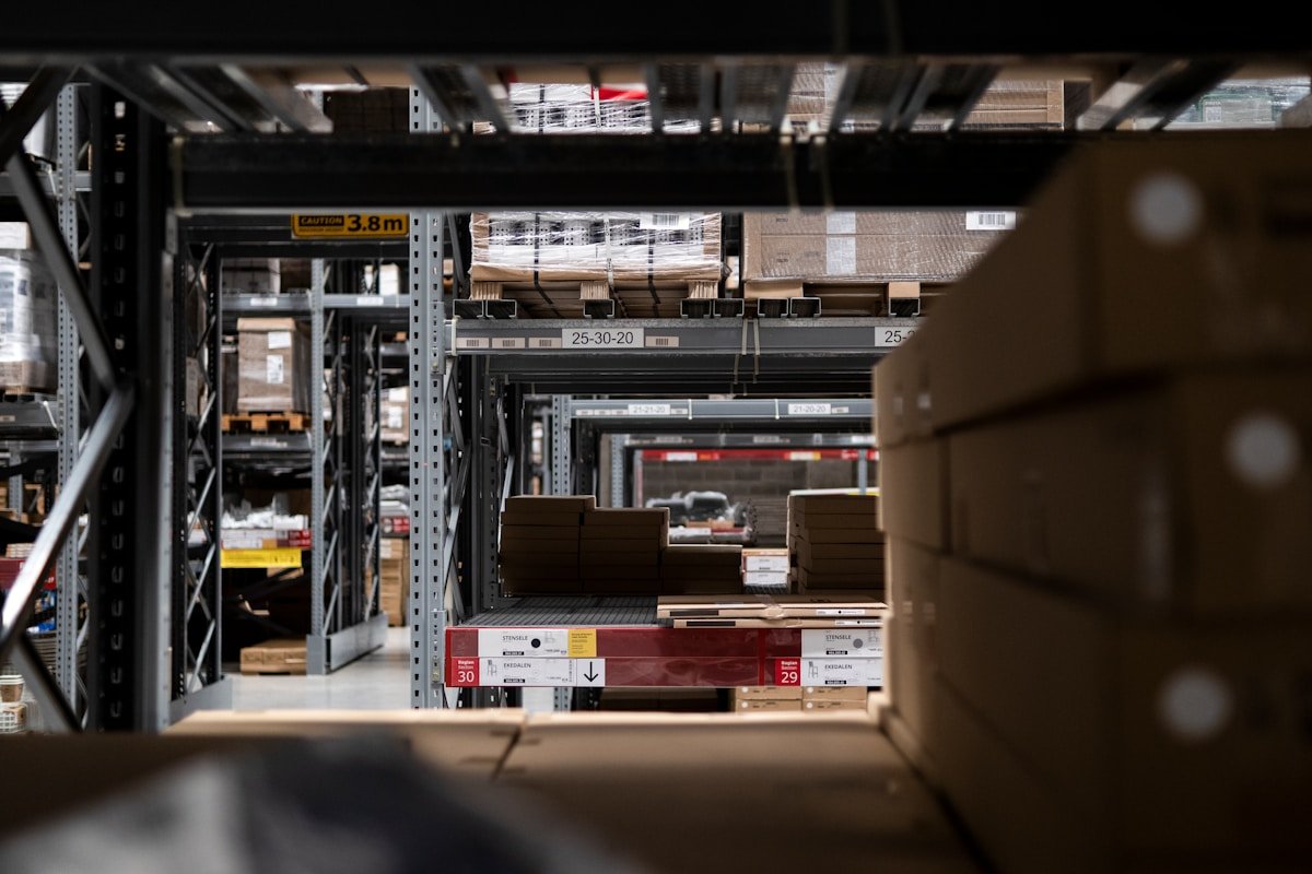 Entrepôt industriel avec étagères, boîtes et palettes.