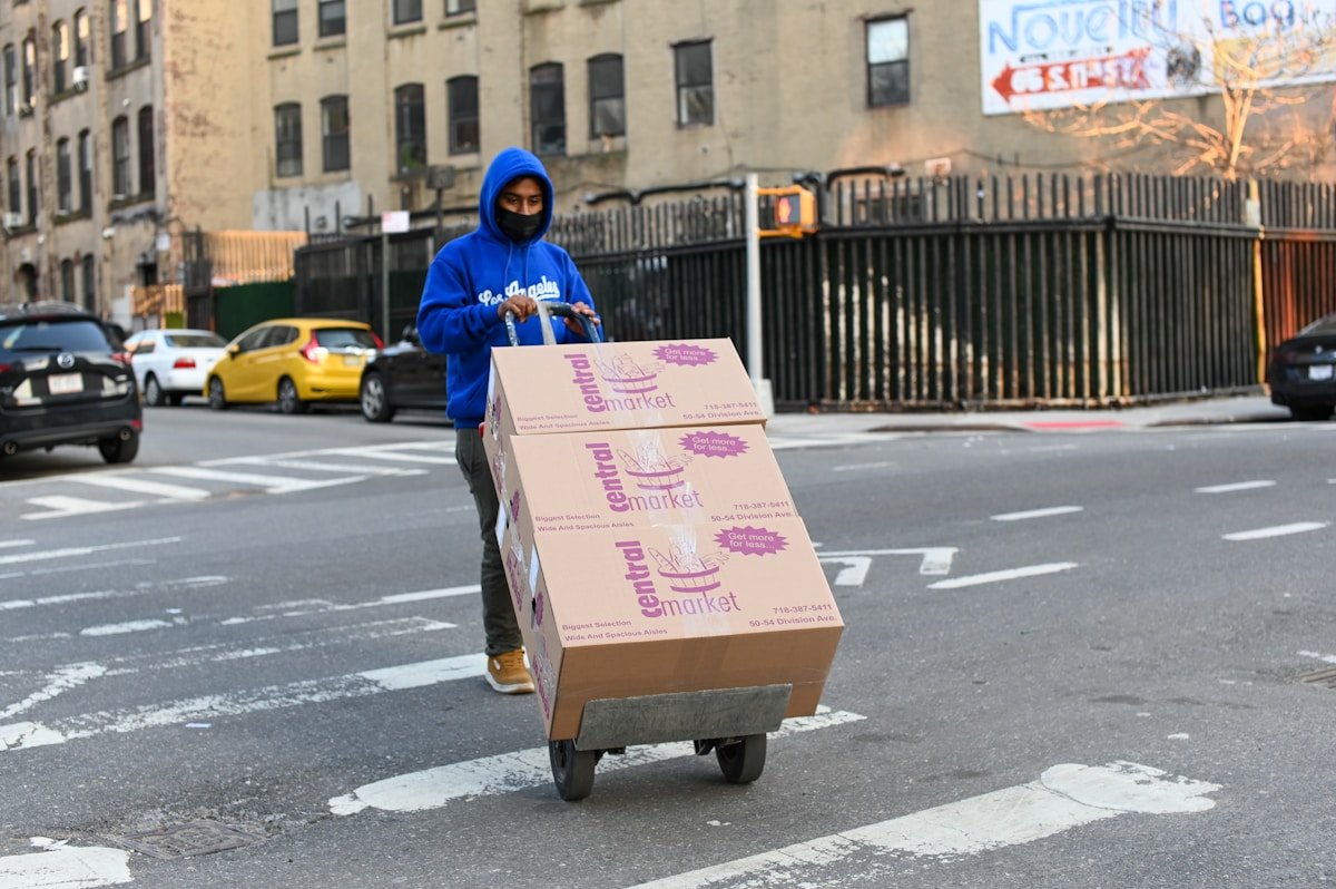 Livreur transportant des boîtes de la Central Market dans une rue de ville.
