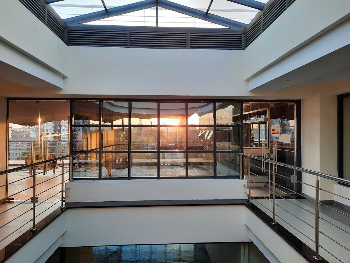 Intérieur moderne avec grandes fenêtres panoramiques et vue sur la ville.