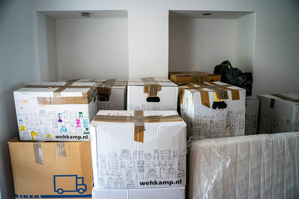 Pièce remplie de cartons de déménagement et matelas emballés